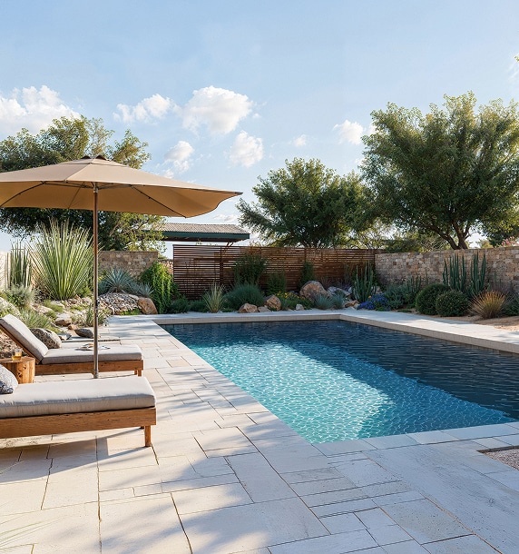 Piscine et Jardin Désertique : Oasis de Luxe et Design Moderne Piscine rectangulaire, chaises longues et parasol beige sur terrasse carrelée claire. Jardin désertique luxuriant, mur de pierre et ciel bleu.